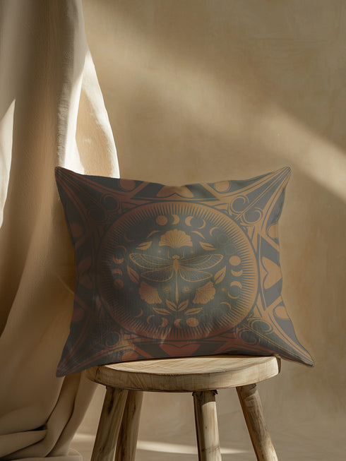Square pillow cover featuring a detailed copper dragonfly illustration centered in a circular medallion with moon phases and Art Deco geometric patterns on a dark gray background.